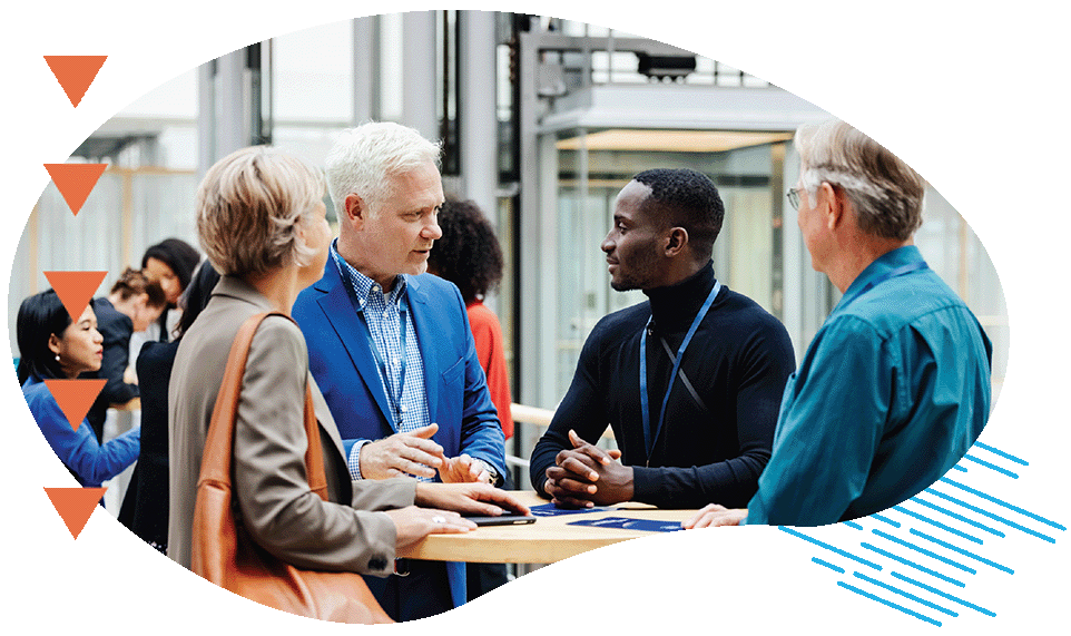 A group of business conference participants discussing a presentation in the hotel foyer together.